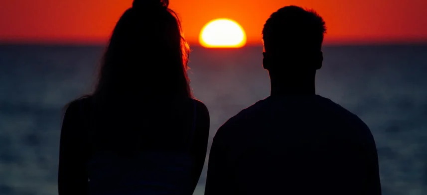 silhouette-couple-enjoying-beautiful-sunset-shore-sea